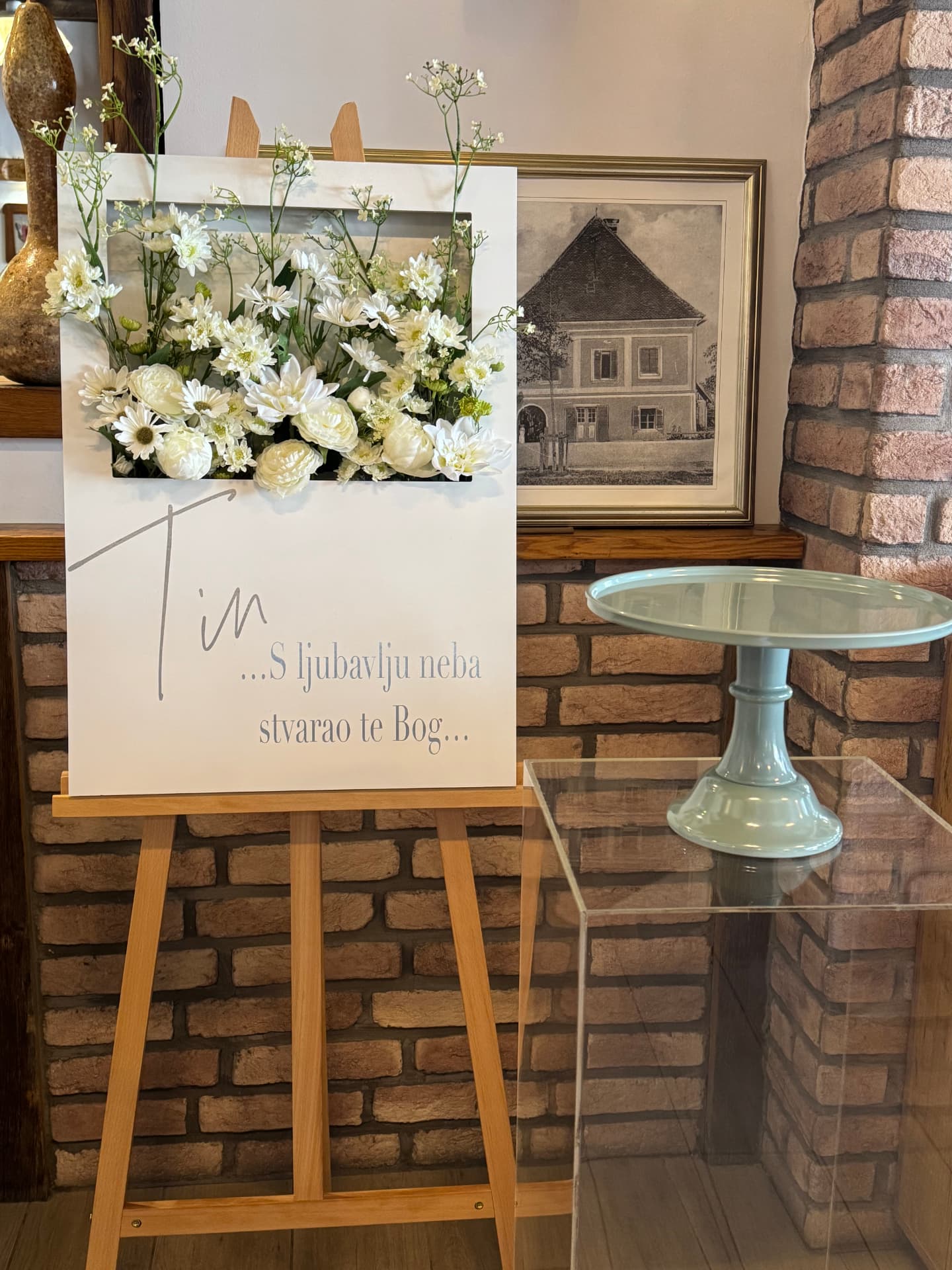 Flower frame ploča s bijelim cvijećem na drvenom stalku za krštenje