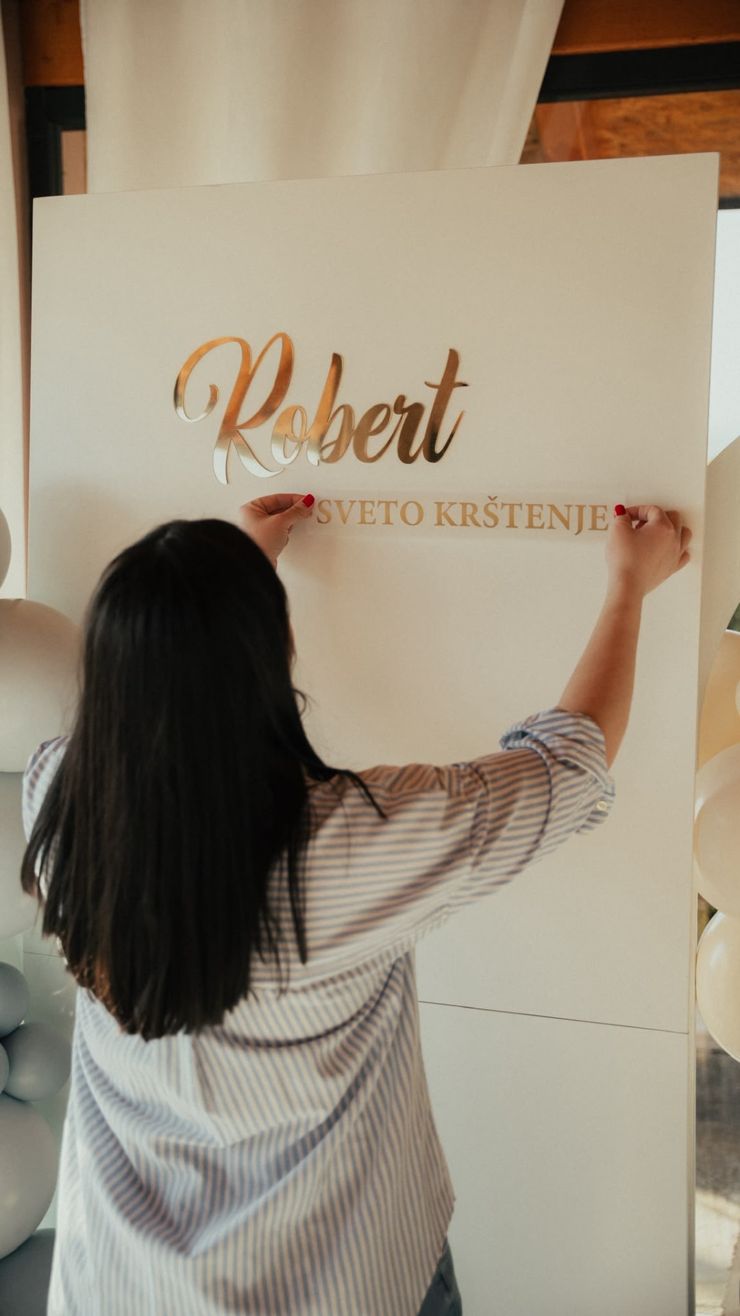 Postavljanje zlatnog natpisa Robert i Sveto krštenje na bijelu ploču